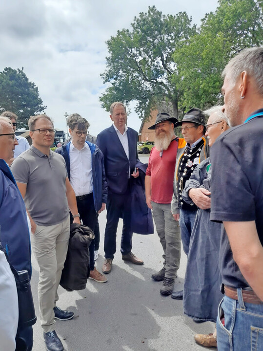 Bundesumweltminister Carsten Schneider (2. v.l.) und Dr. Till Backhaus, Landwirtschafts- und Umweltminister des Landes Mecklenburg-Vorpommern (l.), im Austausch mit Schfern auf der Insel Rgen.