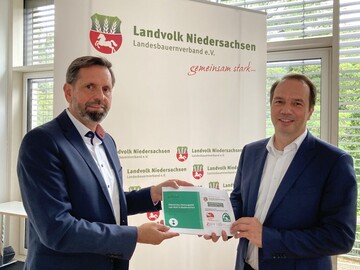 Olaf Lies, Minister fr Umwelt, Energie, Bauen und Klimaschutz Niedersachsen (li.) und Jrn Ehlers, Vizeprsident Landvolk Niedersachsen (re.) mit der Umfrage Wolf.